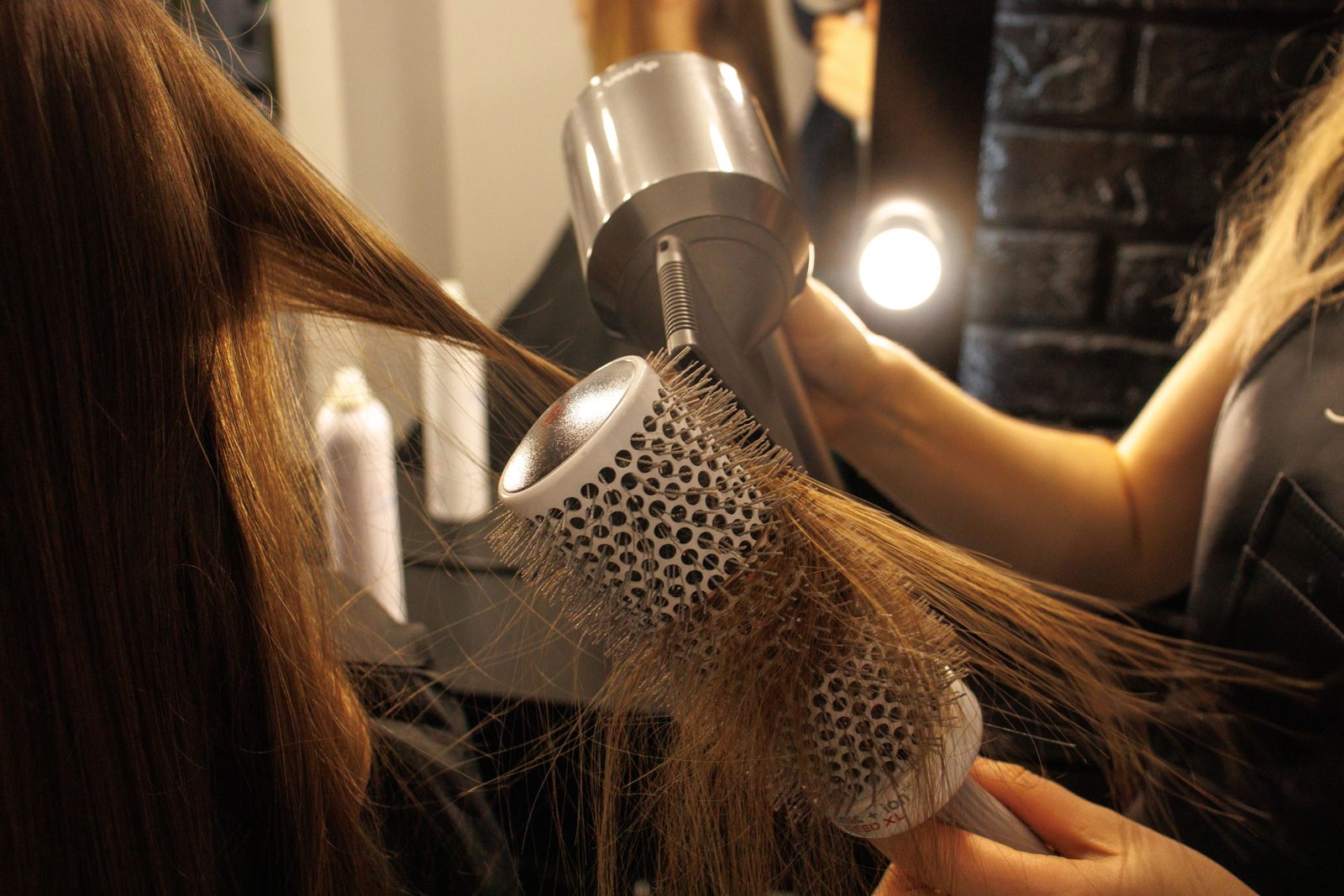 Une femme aux cheveux cuivrés sèche ses longueurs au sèche-cheveux